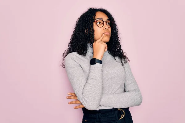 Młoda Afroamerykanka Swetrze Golfem Okularami Różowym Tle Ręką Podbródku Myśląca — Zdjęcie stockowe