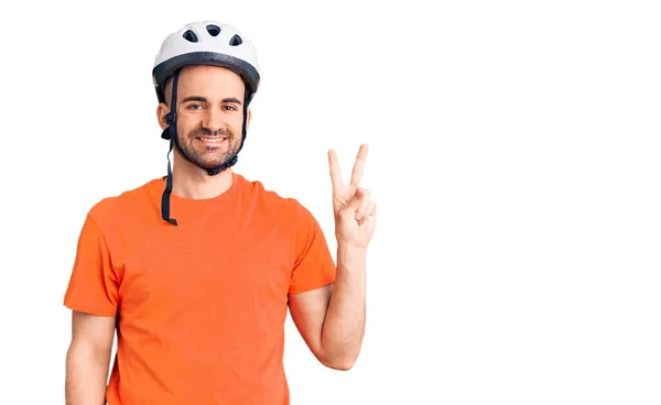年轻英俊的男子戴着自行车头盔 笑容满面 在镜头前眨眼示意胜利 第二点 — 图库照片