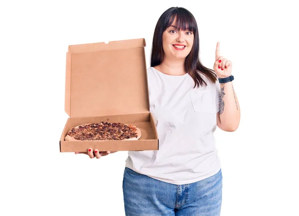Młoda Size Kobieta Trzyma Pudełko Pizzą Zaskoczona Pomysłem Lub Pytaniem — Zdjęcie stockowe
