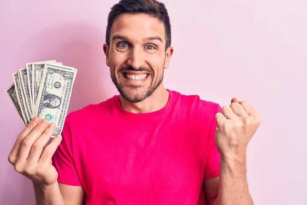 Молодий Красивий Чоловік Тримає Купу Доларів Банкноти Над Ізольованим Рожевим — стокове фото