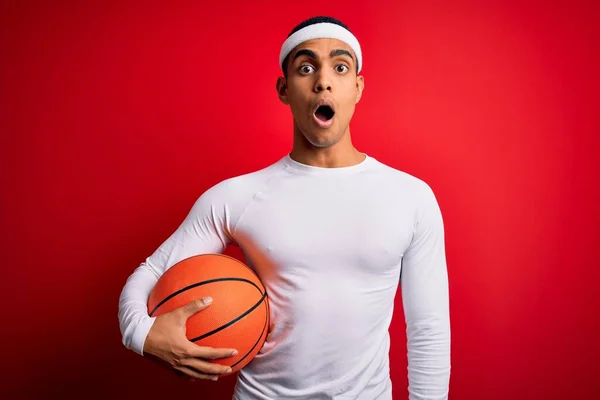 Jonge Knappe Afro Amerikaanse Sportman Houdt Basketbal Rode Achtergrond Bang — Stockfoto