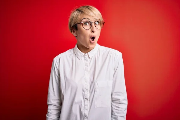Junge Blonde Geschäftsfrau Mit Kurzen Haaren Brille Über Rotem Hintergrund — Stockfoto
