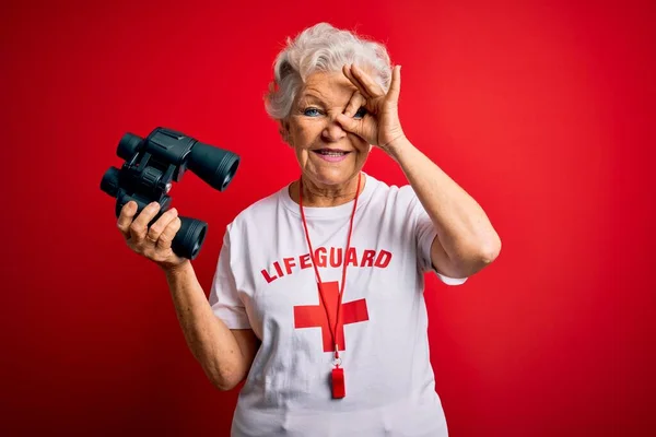 Senior Schöne Grauhaarige Rettungsschwimmerin Mit Fernglas Und Pfeife Über Rotem — Stockfoto