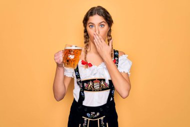 Mavi gözlü, güzel, sarışın bir Alman kadın. Ekim festivali elbisesi giyiyor. Bira kavanozu içiyor. Ağzı kapalı.