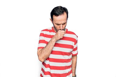 İzole edilmiş beyaz arka plan üzerinde duran çizgili tişört giyen yakışıklı bir adam kendini iyi hissetmiyor ve soğuk algınlığı veya bronşitin belirtisi olarak öksürüyor. Sağlık hizmeti kavramı.