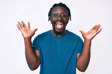 Saçları örgülü genç Afro-Amerikan bir adam çılgın kutlamalar yapıyor ve kolları açık ve gözleri açık heyecanla haykırarak başarıyı kutluyor. Kazanan konsept 