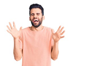 Genç, sakallı, sıradan tişörtlü, çılgın ve başarıyı kolları havada ve gözleri kapalı heyecanla bağırarak kutlayan yakışıklı bir adam. Kazanan konsept 