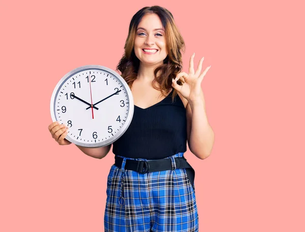 Joven Hermosa Mujer Caucásica Sosteniendo Gran Reloj Haciendo Signo Con —  Fotos de Stock