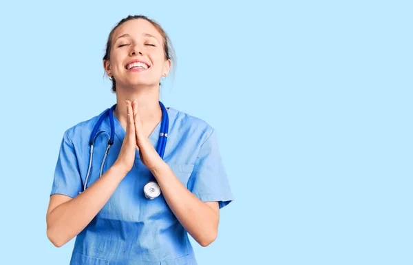 Jovem Mulher Loira Bonita Vestindo Uniforme Médico Estetoscópio Implorando Orando — Fotografia de Stock