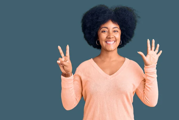 Young african american girl wearing casual clothes showing and pointing up with fingers number seven while smiling confident and happy.