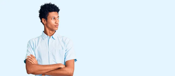 若いアフリカ系アメリカ人の男性が腕を横に見てカジュアルな服を着て確信と自信を越え — ストック写真