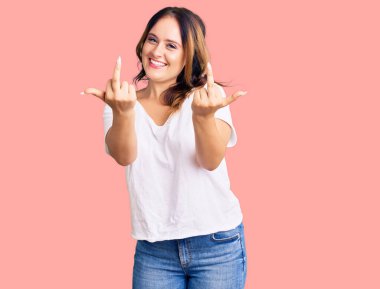 Young beautiful caucasian woman wearing casual white tshirt showing middle finger doing fuck you bad expression, provocation and rude attitude. screaming excited 