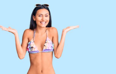 Bikini giyen ve güneş gözlüğü takan genç, güzel bir Latin kız çılgın kutlamalar yapıyor ve kolları açık, gözleri açık heyecanla haykırıyor. Kazanan konsept 