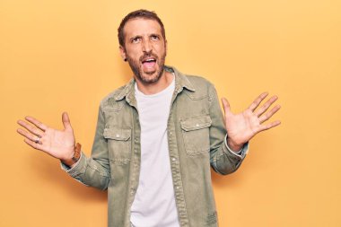 Genç, yakışıklı, sıradan kıyafetler giyen çılgın ve deli gibi bağıran agresif bir ifade ve kollarla bağıran bir adam. hüsran kavramı. 