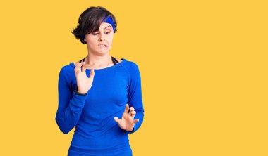 Kısa saçlı, antrenman kıyafetleri giyen güzel bir genç kadın. İfade tiksindirici ve tiksindirici bir ifade takınıyordu. Tiksinti ifadesi takınıyordu.. 