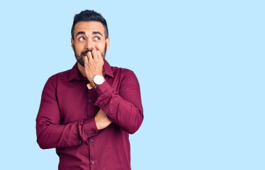 Günlük kıyafetler giyen genç İspanyol adam gergin ve gergin görünüyor. Ağzı tırnak yiyen eller. anksiyete. 