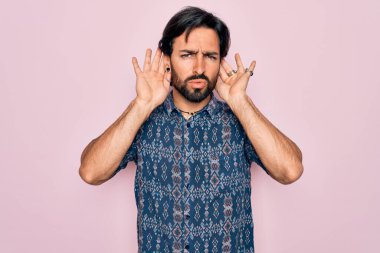 Pembe arka planda hippi tarzı giyinmiş genç, Latin asıllı bohem adam iki elini de kulak hareketi yaparken duymaya çalışıyor. Dedikoduya meraklı. İşitme problemi, sağır