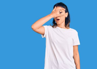 Gündelik kıyafetler giyen genç bir kadın şok içinde yüzünü ve gözlerini kapayarak utanmış ifadesiyle parmaklarının arasından bakıyor.. 