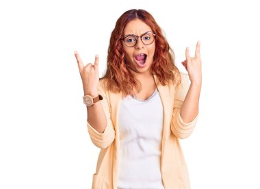 İş kıyafetleri giymiş, çılgın bir ifadeyle bağıran genç Latin kadın elleri havada rock sembolü yapıyor. Müzik yıldızı. ağır kavram. 