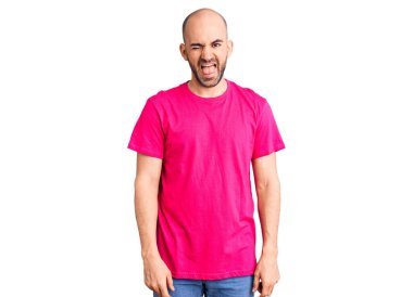 Gündelik tişört giyen genç yakışıklı adam kameraya seksi bir ifadeyle bakıyor, neşeli ve mutlu bir yüzle.. 