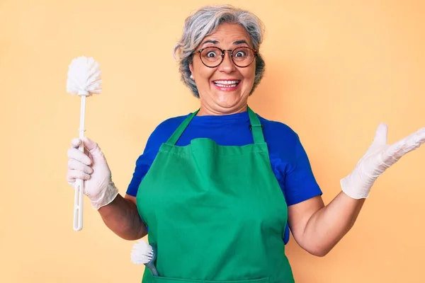 Mulher Hispânica Sênior Vestindo Avental Segurando Escova Celebrando Vitória Com — Fotografia de Stock