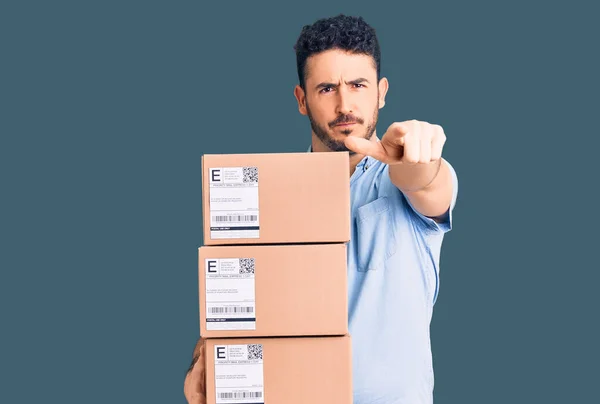 Young Hispanic Man Holding Delivery Package Pointing Finger Camera You — Stock Photo, Image