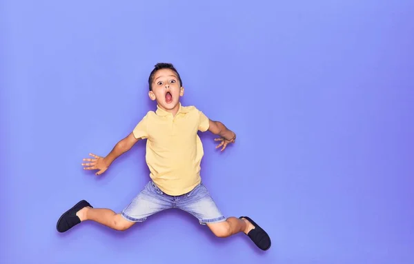 Criança Adorável Vestindo Roupas Casuais Pulando Sobre Fundo Roxo Isolado — Fotografia de Stock