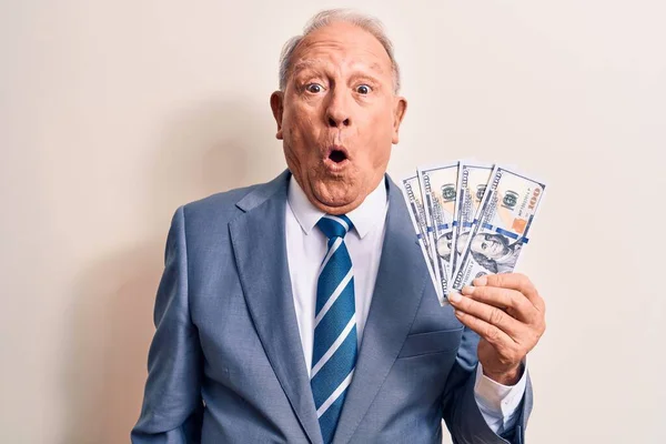 Starszy Przystojny Siwowłosy Biznesmen Garniturze Trzymający Kilka Dolarów Banknotów Przerażony — Zdjęcie stockowe