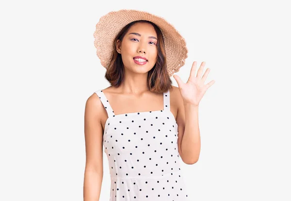 年轻美丽的中国姑娘头戴夏帽 头戴五号手指 面带微笑 自信而快乐 — 图库照片