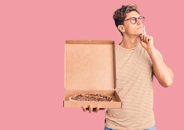 Νεαρός Όμορφος Άντρας Που Κρατάει Κουτί Της Πίτσας Σοβαρά Σκεπτόμενος — Φωτογραφία Αρχείου