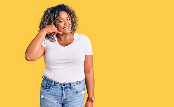 若いアフリカ系アメリカ人に加え 携帯電話で話すような手や指で携帯電話のジェスチャーを行う笑顔カジュアルな服を着てサイズの女性 コミュニケーションの概念 — ストック写真