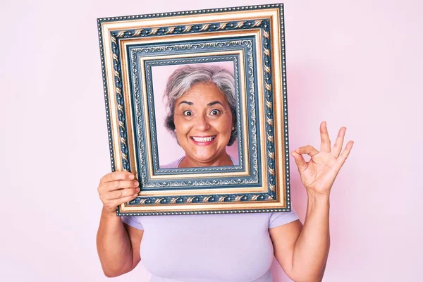 Senior Hispanic Woman Holding Empty Frame Doing Sign Fingers Smiling — Stock Photo, Image