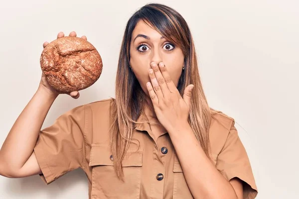 Jovem Bela Mulher Segurando Pão Cobrindo Boca Com Mão Chocado — Fotografia de Stock