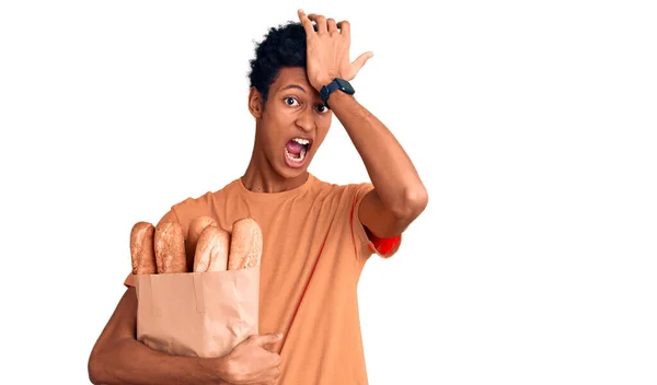 Jovem Afro Americano Segurando Saco Papel Com Pão Surpreso Com — Fotografia de Stock