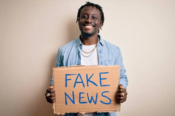 Młody Afroamerykanin Trzymający Sztandar Fałszywymi Wiadomościami Białym Tle Szczęśliwą Twarzą — Zdjęcie stockowe