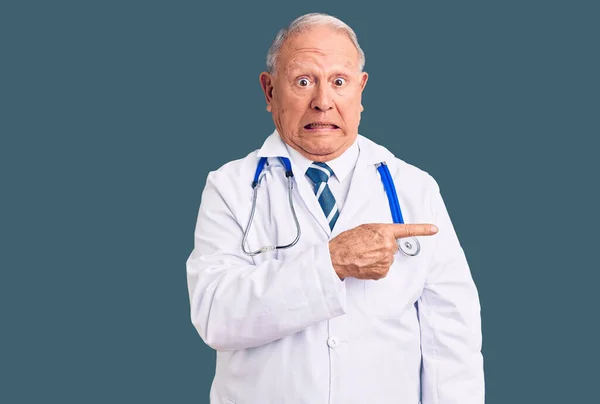 Senior Pohledný Šedovlasý Muž Lékařském Kabátě Stetoskopu Ukazuje Stranou Ustaraný — Stock fotografie