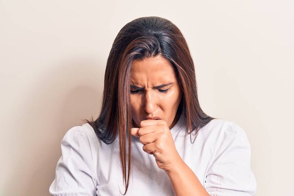 Young beautiful brunette woman wearing casual t-shirt feeling unwell and coughing as symptom for cold or bronchitis. health care concept. 