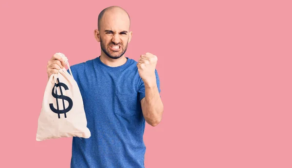 Jovem Homem Bonito Segurando Saco Dinheiro Com Símbolo Dólar Irritado — Fotografia de Stock