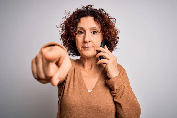 Mulher Encaracolada Meia Idade Conversando Smartphone Sobre Fundo Branco Apontando — Fotografia de Stock