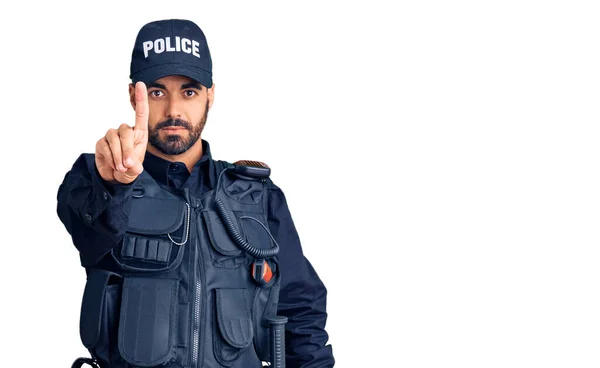 警察の制服を着た若いヒスパニック系の男が指を上げて怒りの表情で指摘し ジェスチャーを示さない — ストック写真