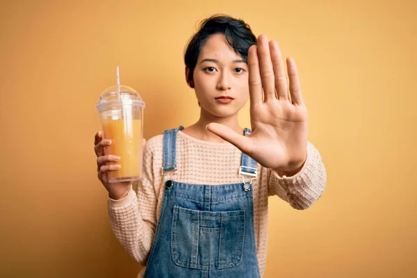 Jonge Mooie Chinese Vrouw Drinken Gezond Sinaasappelsap Geïsoleerde Gele Achtergrond — Stockfoto