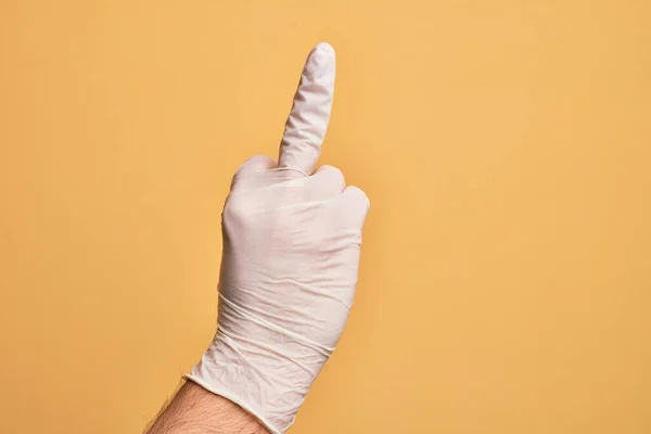 Mão Caucasiano Jovem Com Luva Médica Sobre Fundo Amarelo Isolado — Fotografia de Stock