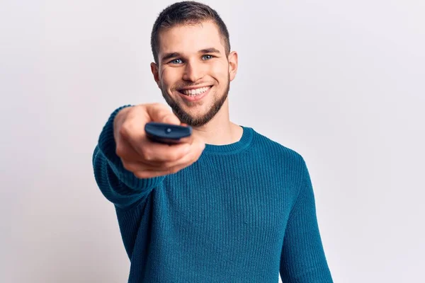 Jovem Homem Bonito Segurando Controle Remoto Olhando Positivo Feliz Sorrindo — Fotografia de Stock