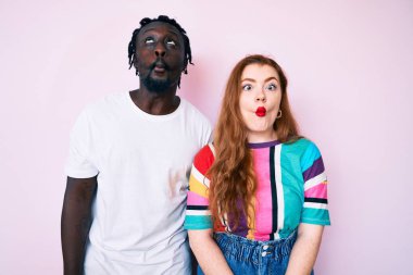 Irklar arası çift gündelik kıyafetler giyip dudaklarıyla balık suratı yapıyorlar, çılgınca ve komik bir jest. Komik ifade. 