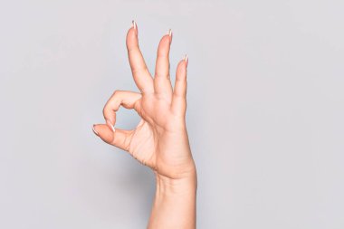 Beyaz tenli genç bir kadının el hareketi. Onaylama ifadesi. Parmaklarıyla sembol çiziyor.