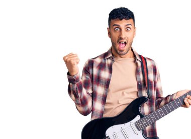 Genç İspanyol gitar çalan gururlu genç adam zaferi ve başarıyı kollarını kaldırarak kutluyor. 