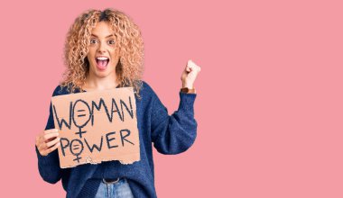 Sarışın, kıvırcık saçlı genç bir kadın. Değişiklik afişine ihtiyacımız var. Gururla bağıran, zaferi kutlayan ve kollarını kaldırarak heyecanlanan bir pankarta. 