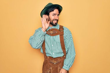 Almanya festivali için geleneksel Alman Ekim Festivali kıyafeti giymiş yakışıklı bir adam. Kulaktan kulağa gülüyor. Dedikodulara ve dedikodulara kulak veriyor. Sağırlık kavramı.