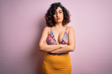 Tatilde olan genç, güzel bir Arap kadın. Pembe arka plan üzerinde mayo ve güneş gözlüğü takıyor. Kuşkucu ve gergin. Negatif kişi.