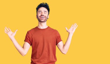 Gündelik kıyafetler giyen genç İspanyol adam zaferi mutlu bir gülümsemeyle ve kazanan yüz ifadesiyle kutluyor. 